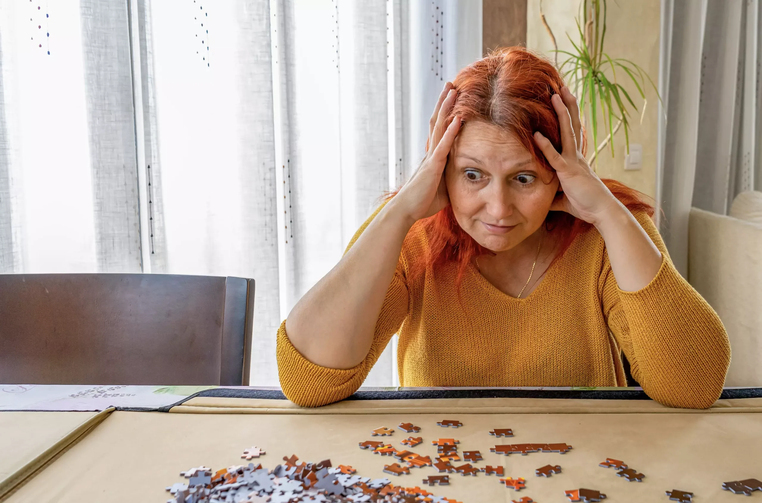 Mujer con TDAH en adultos mostrando frustración al intentar completar un rompecabezas.