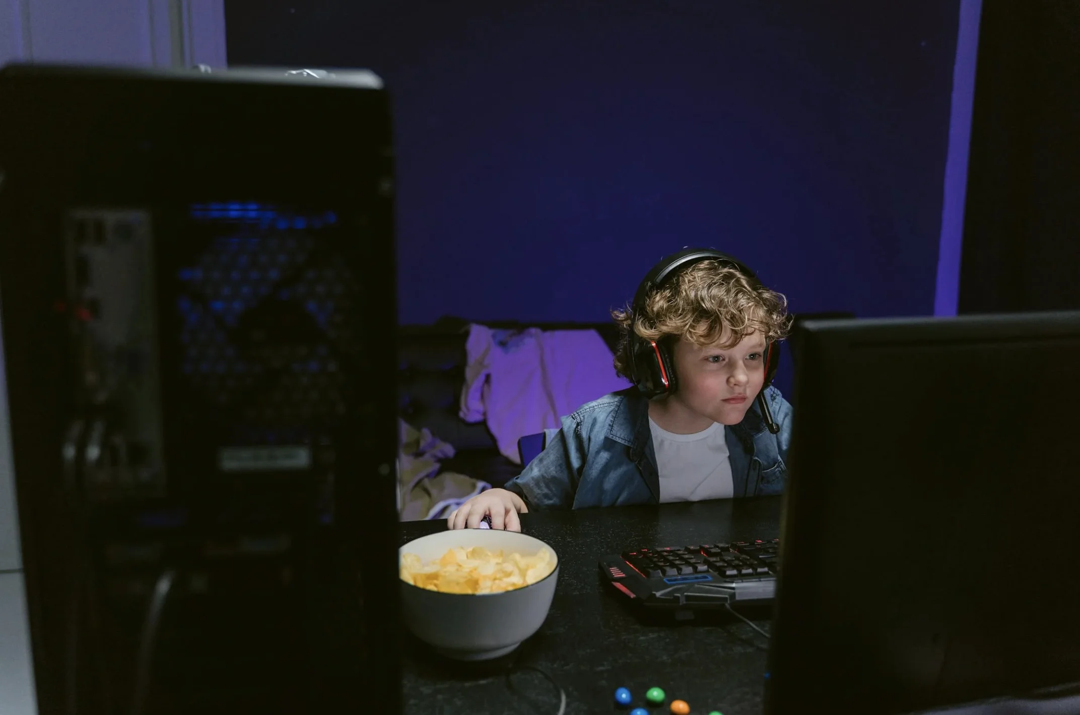 Niño jugando videojuegos online con auriculares, un ejemplo para explicar el riesgo de grooming y cómo Centro Imago Villalba acompaña a las familias en la seguridad digital.